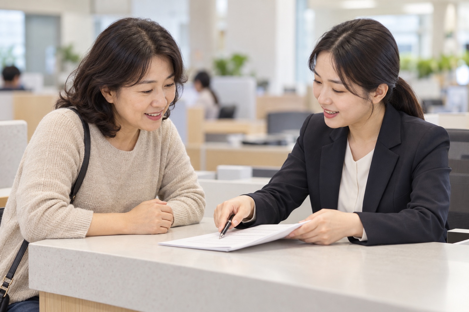 공공기관 상담 창구에서 서류를 함께 살펴보는 여성 임차인과 상담사